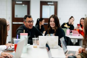 David Saca Hernandez, special education faculty, teaching at a table with students.